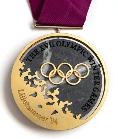 Front: Lillehammer 1994 gold medal, Olympic rings over granite with legend