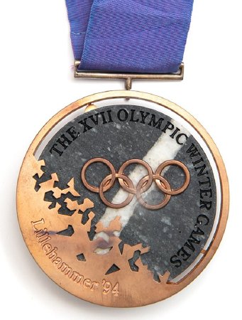 Front: Lillehammer 1994 bronze medal, Olympic rings over granite
