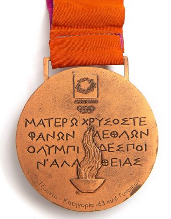 Back: Athens bronze medal, Emblem over Greek writing and Olympic cauldron