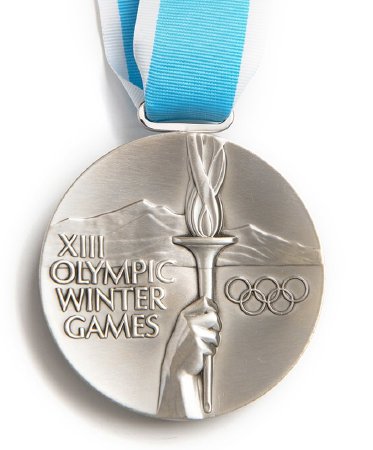 Front: Lake Placid 1980 silver medal, hand holding torch with legend